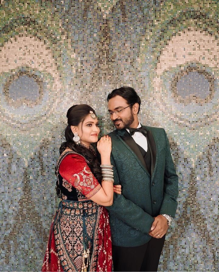 Couple at their reception against a peacock backdrop