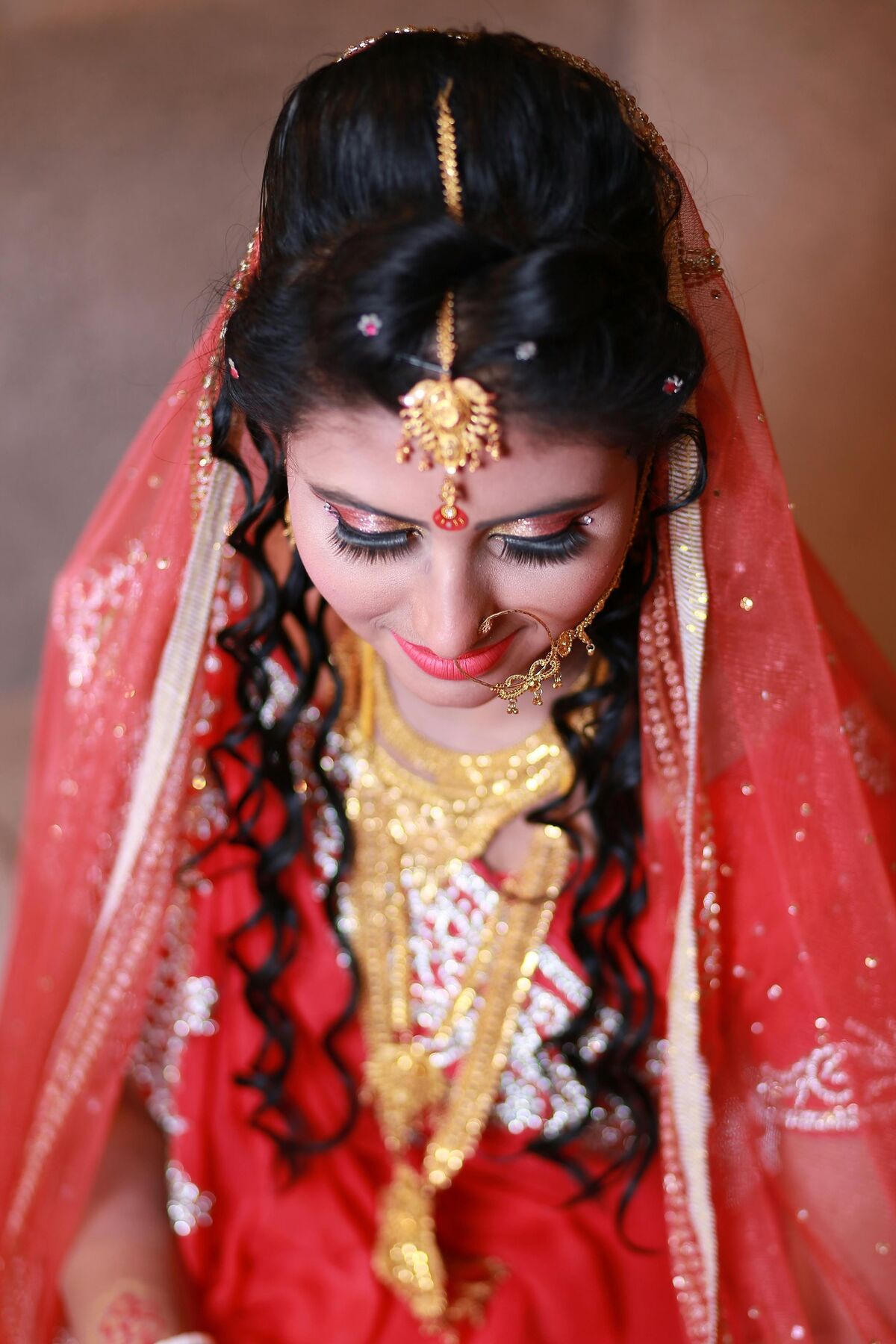 Bride in a red veil looking down